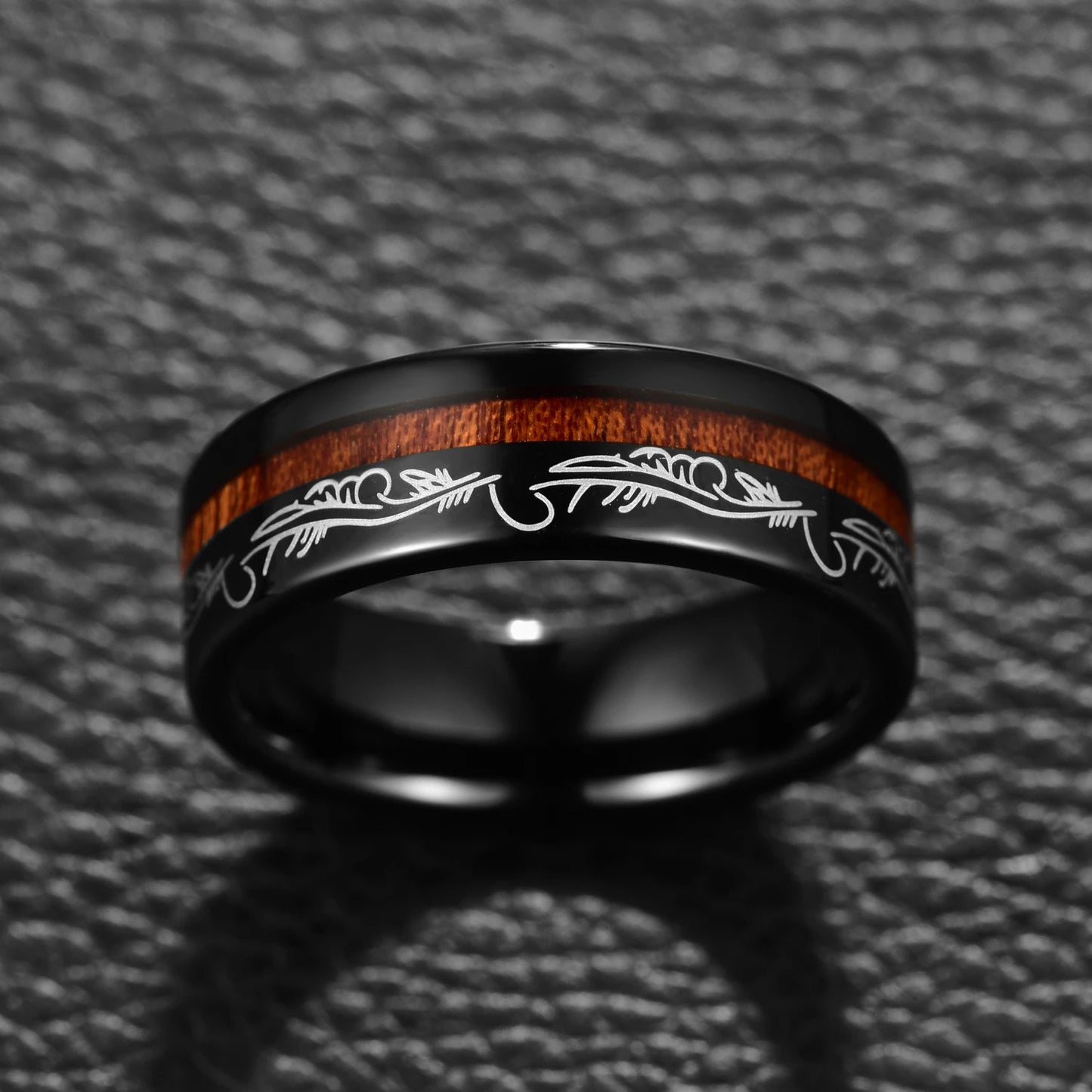 A mens feather ring, with an intricate filigree pattern around the band.