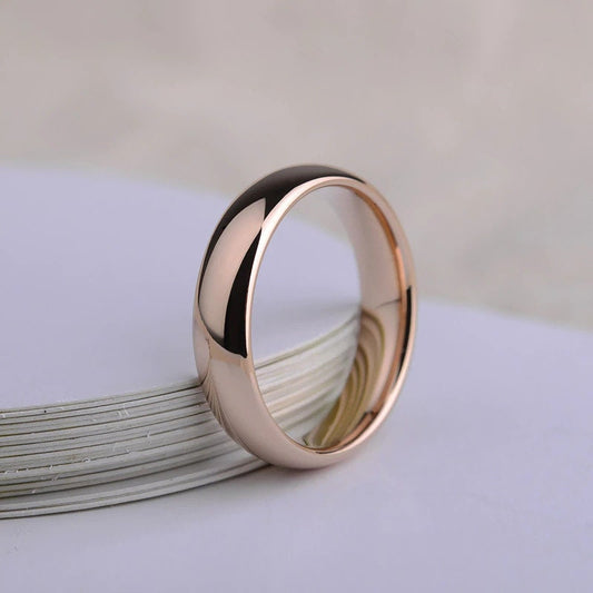 Mens wedding bands rose gold displayed with a side view.