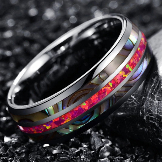 Pink stone ring with a warm-toned pink opal inlay, flanked by iridescent abalone shell.