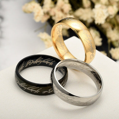 Three Lord of the Rings replica rings in gold, black, and silver displayed together