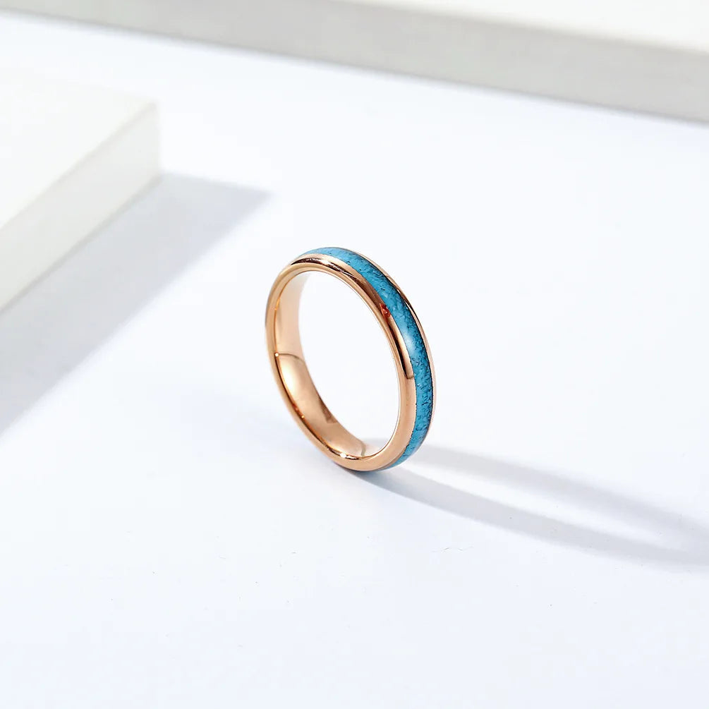 Rose gold Tungsten wedding band with turquoise inlay displayed in a clean, modern setting