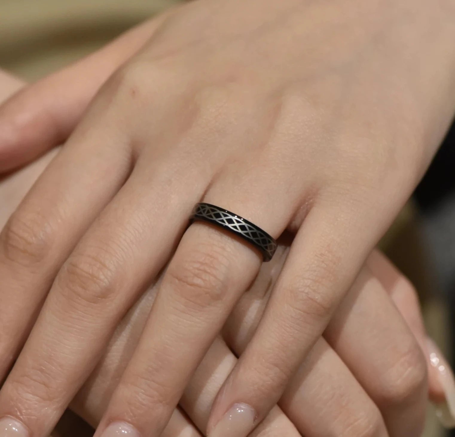 Unisex black Tungsten ring with Celtic braid design, 4mm width, worn on a woman's hand.