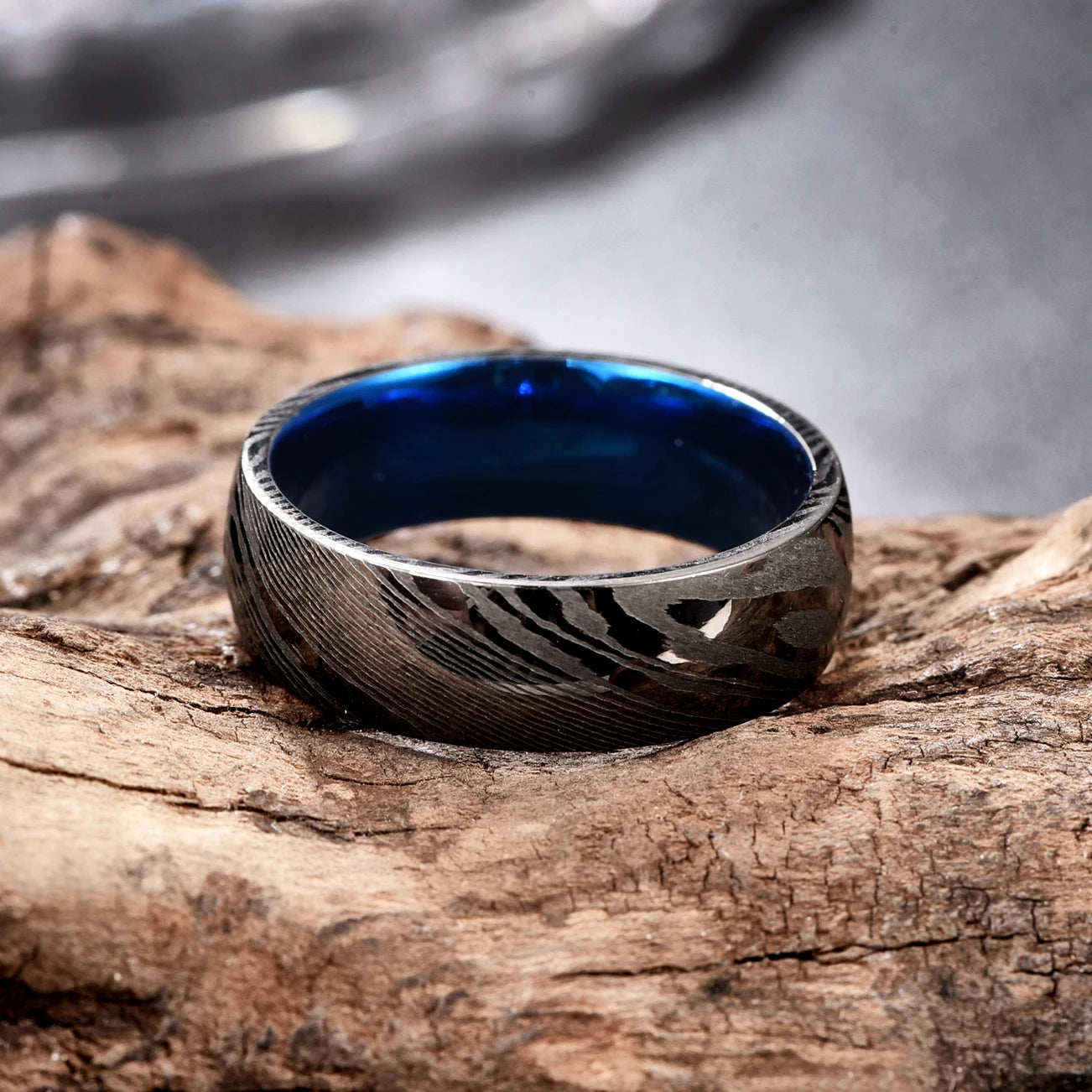 Black blue ring featuring a black Damascus Steel exterior and blue Tungsten interior.