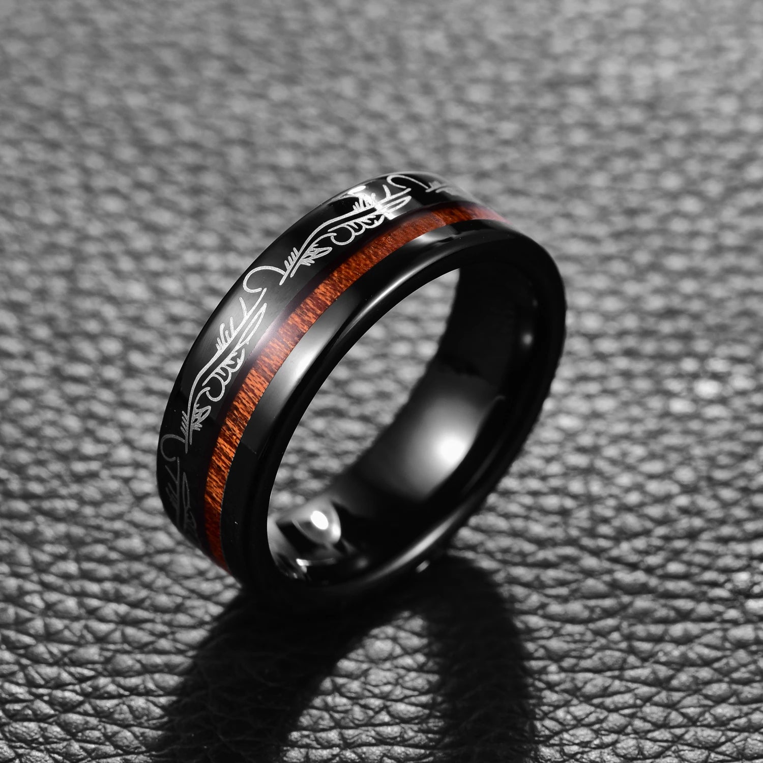 Black Tungsten ring with filigree feather detailing and offset acacia wood inlay, upright view