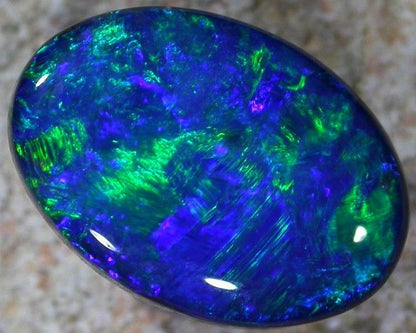 Blue and green opal stone showcasing vibrant natural colors with bright flashes.