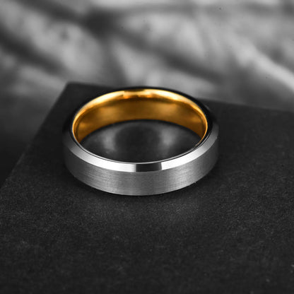 Brushed silver tungsten ring with a polished gold interior, designed for men with beveled edges.