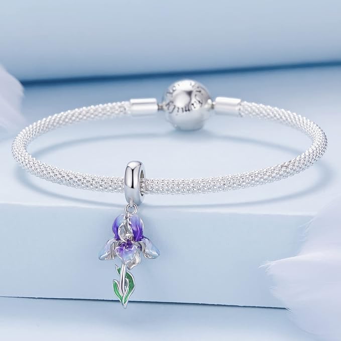 Delicate floral charm featuring a violet and white iris shown on a bracelet.