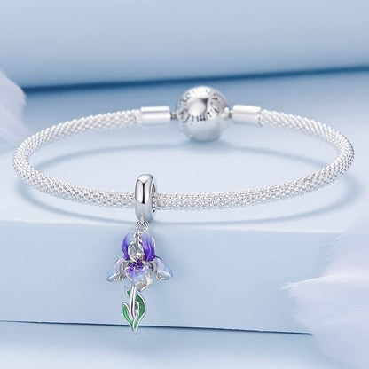 Delicate floral charm featuring a violet and white iris shown on a bracelet.