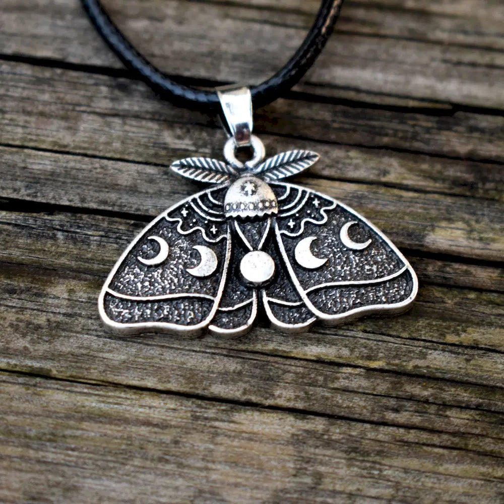 Detailed celestial pendant with a full moon at the center and lunar phases across the wings.