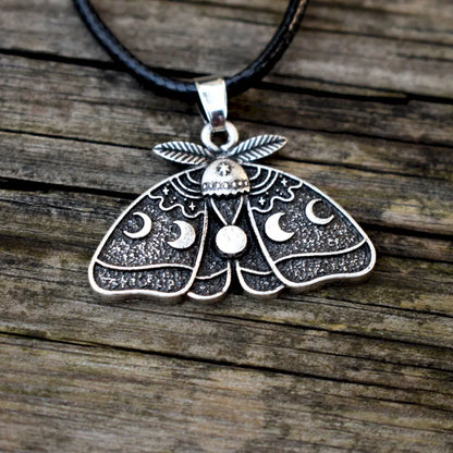 Detailed celestial pendant with a full moon at the center and lunar phases across the wings.