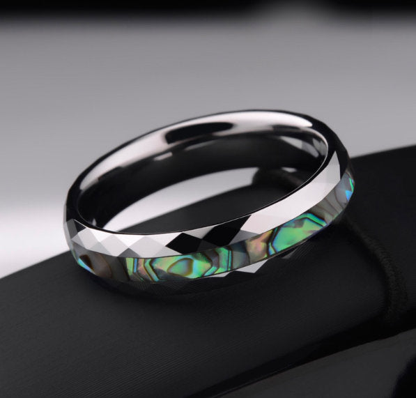 Faceted Tungsten wedding band with abalone shell inlay featuring iridescent blue and green tones.