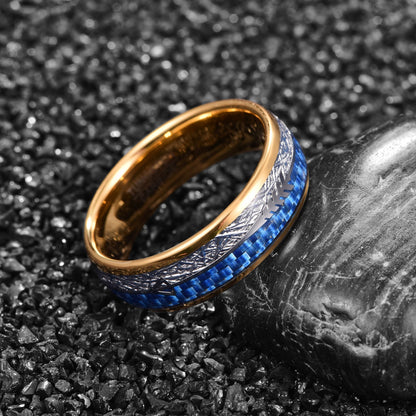 Gold tungsten ring with meteorite and blue carbon fiber inlay featuring an arrow design placed on stone