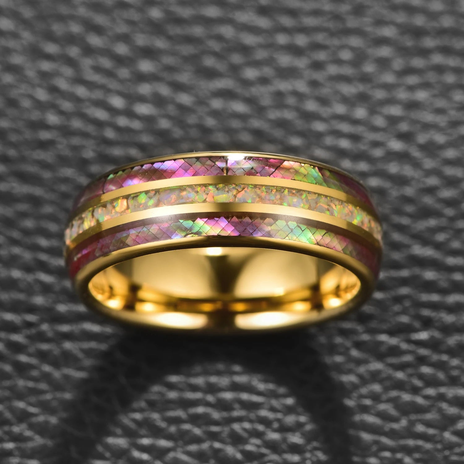 Close-up of gold Tungsten ring with abalone and opal inlay, domed band design