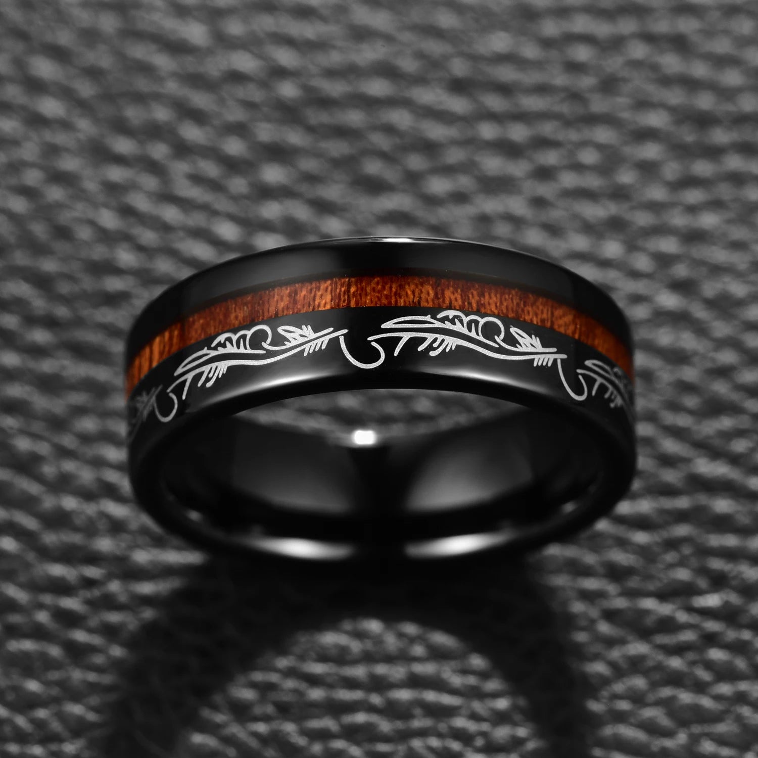 A mens feather ring, with an intricate filigree pattern around the band.