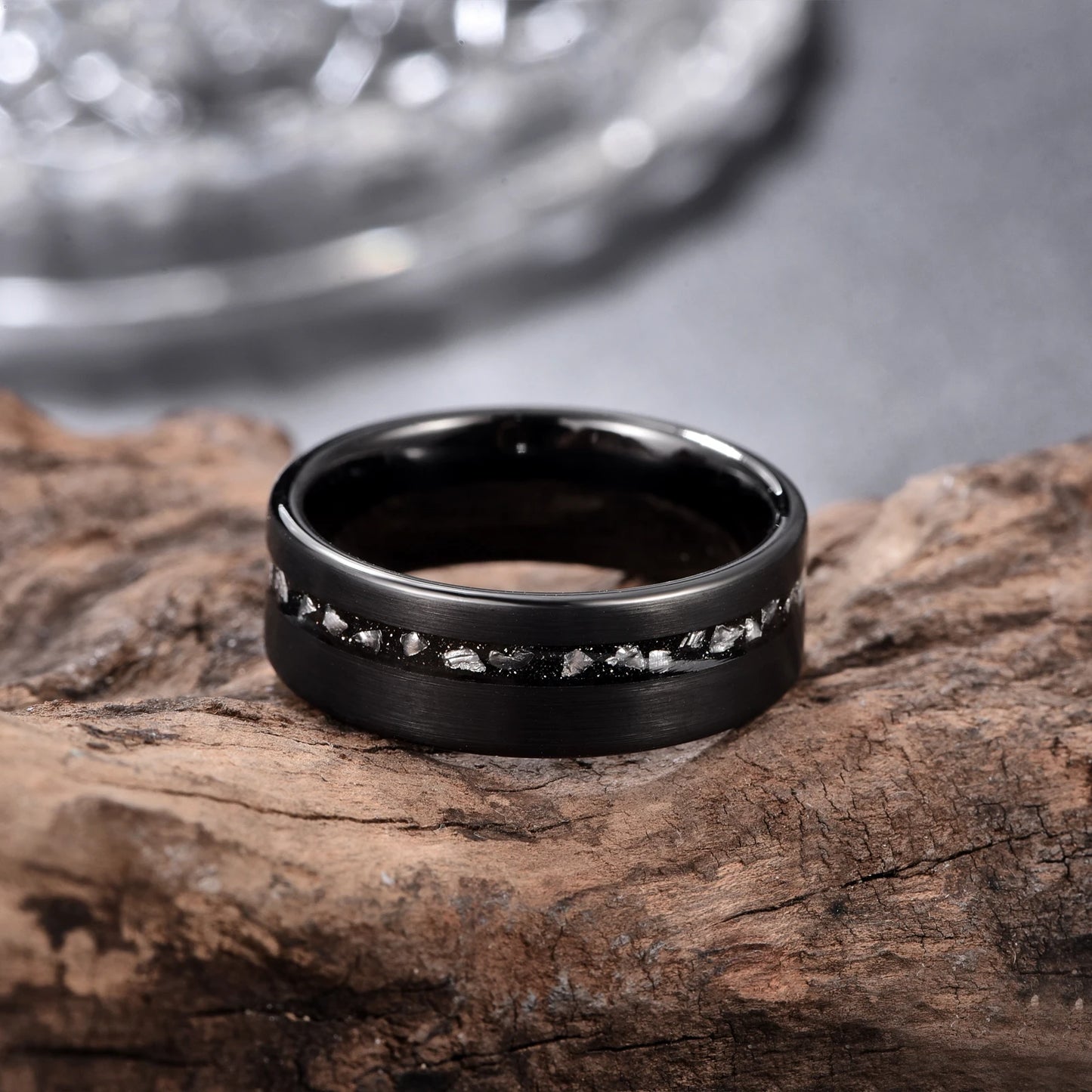 Meteorite fragments inlaid in a Tungsten ring with moon dust and black sandstone.