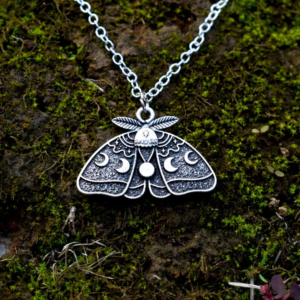 Moth necklace, crafted with detailed moon phases and tiny stars across the wings.