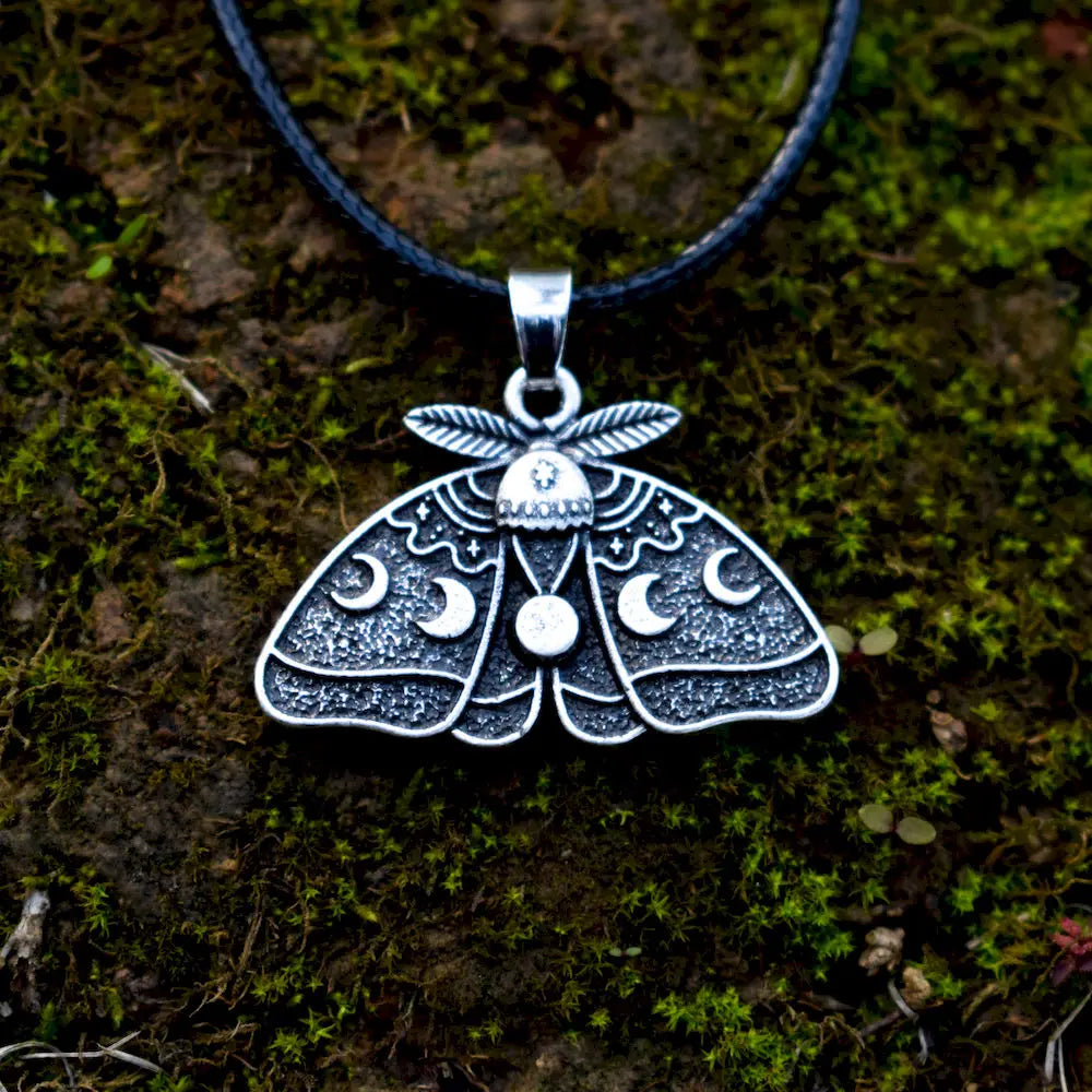 Moth pendant featuring a full moon, waxing and waning moon phases, and stars.