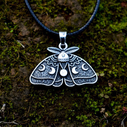 Moth pendant featuring a full moon, waxing and waning moon phases, and stars.