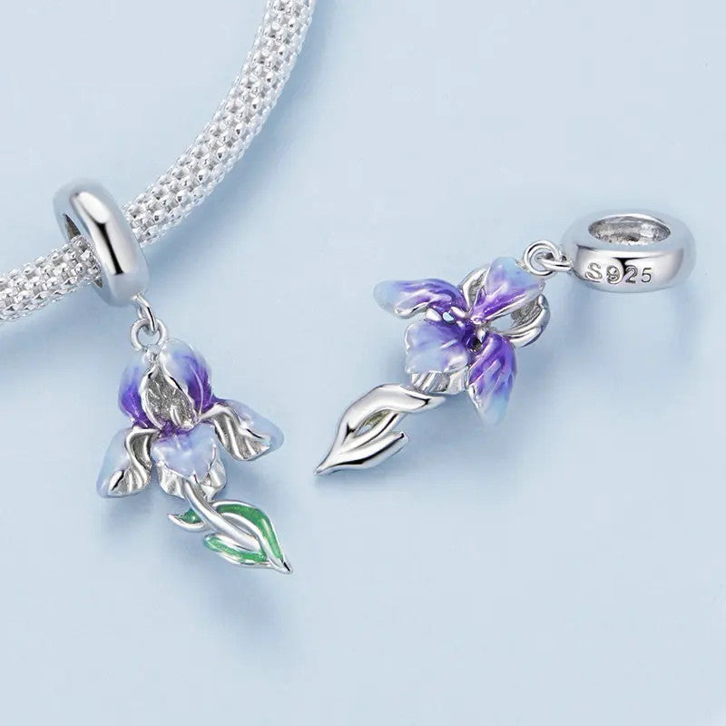 Purple iris charm with layered petals, green leaves, and polished sterling silver details.