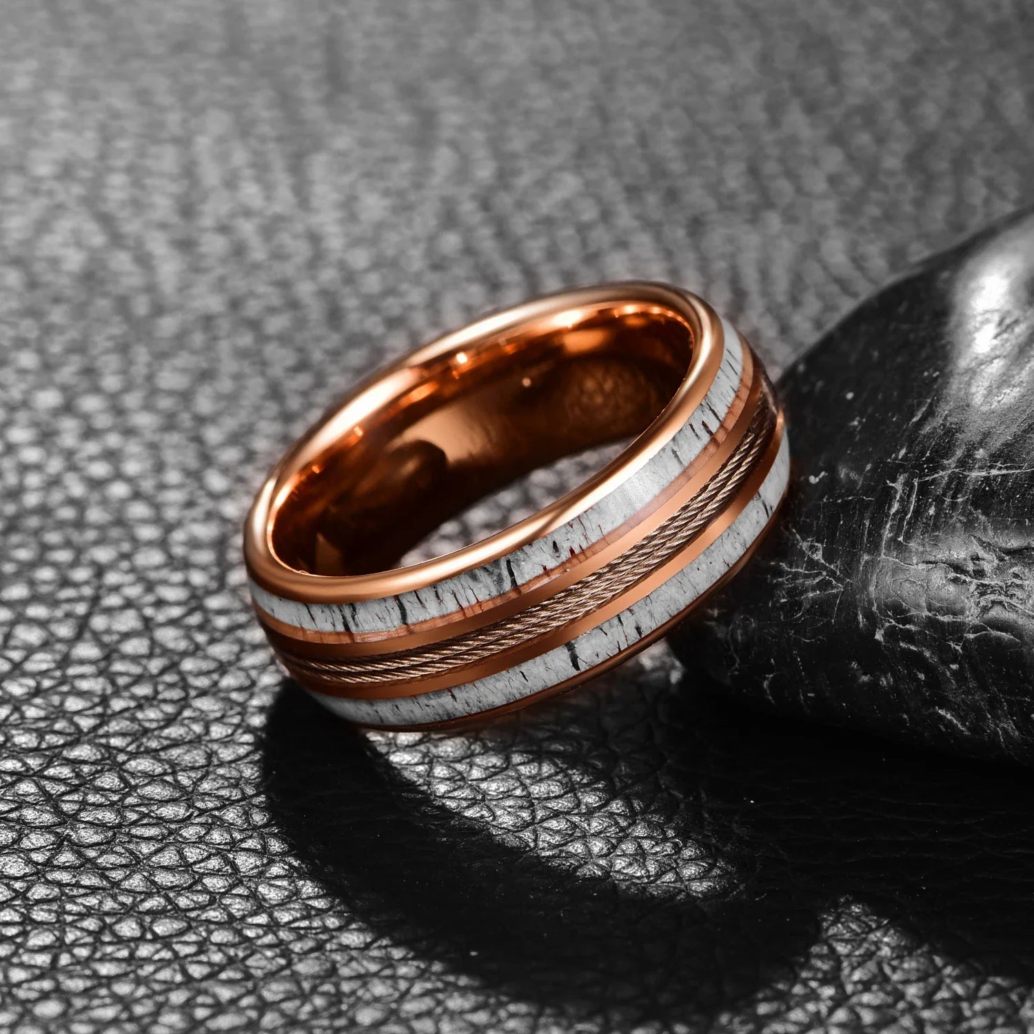 Close-up of rose gold Tungsten ring with deer antler and guitar string inlay, domed band design