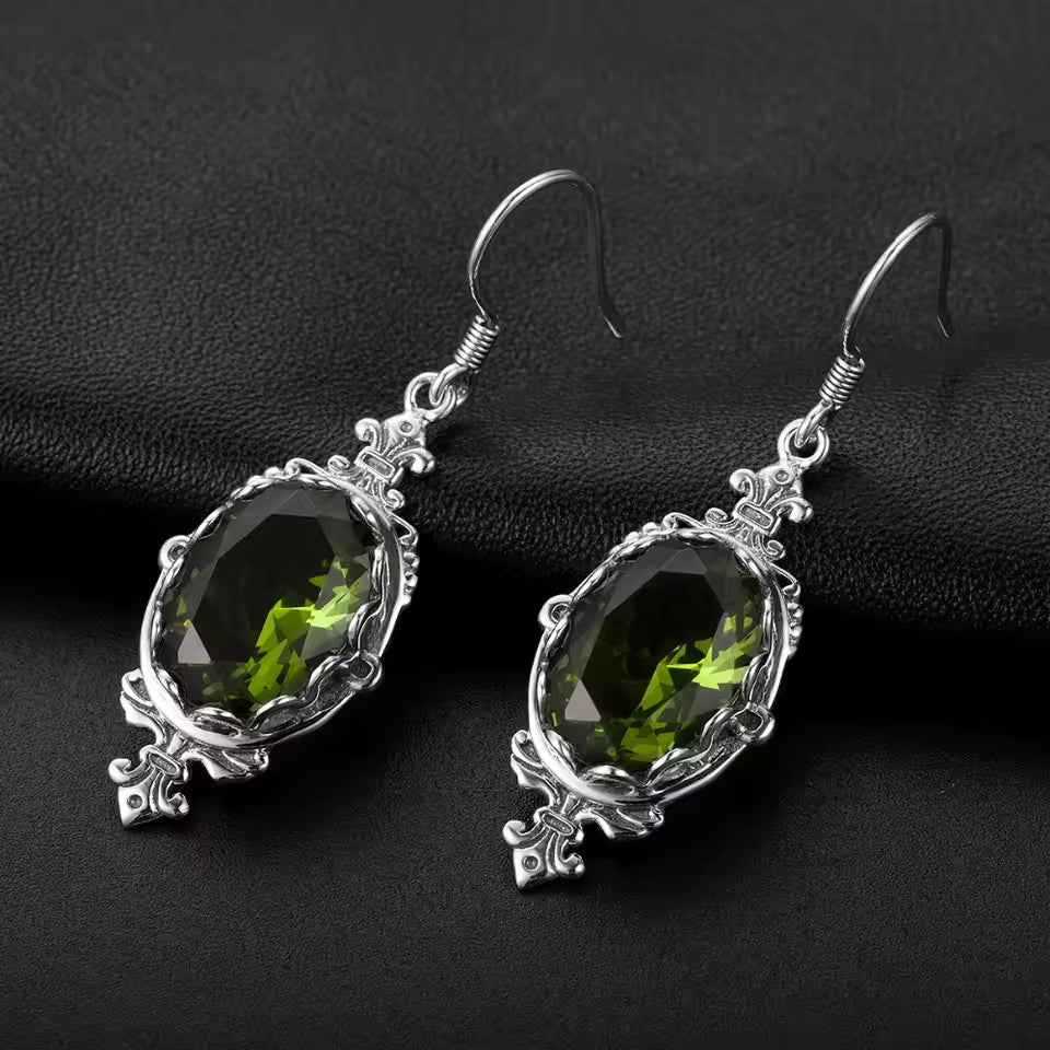 Silver peridot earrings, featuring oval green gemstones set in decorative silverwork.