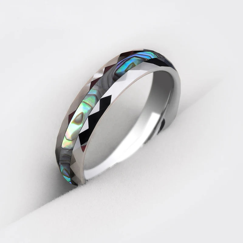 Tungsten ring with abalone shell inlay and faceted edges, showcasing vibrant ocean-inspired colors.