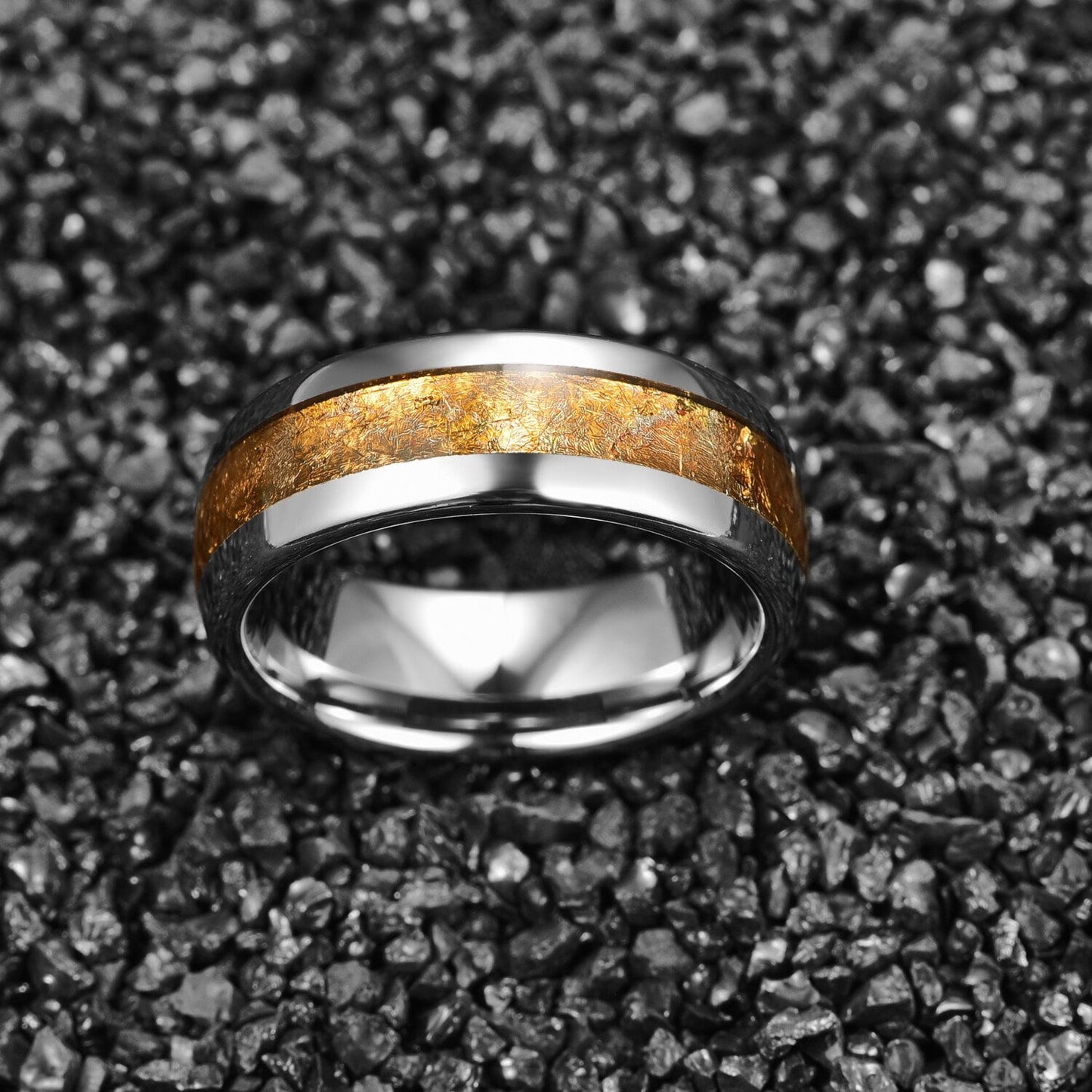 Tungsten ring with gold inlay, shown on black stone background.