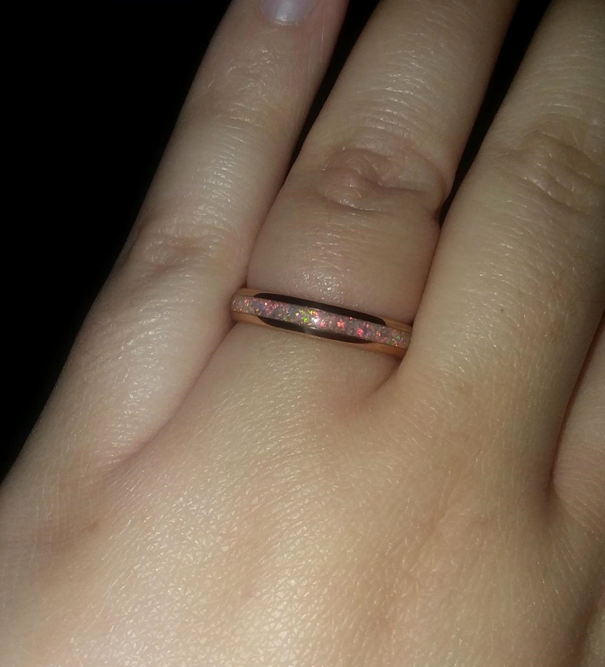 4mm rose gold Tungsten fire opal wedding band on hand, showing the delicate inlay design.