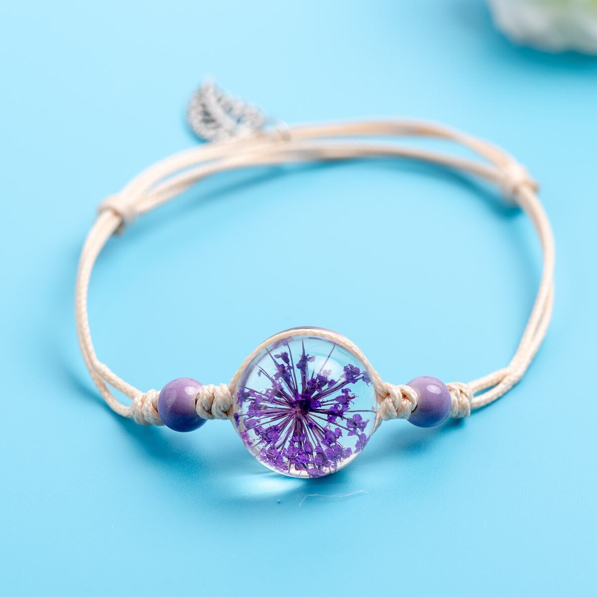 Adjustable nature-inspired bracelet featuring a real preserved botanical beneath a clear round setting.