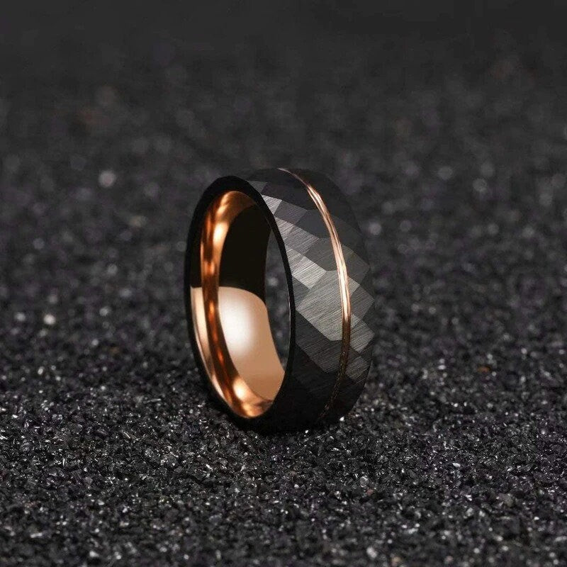 Black Tungsten faceted ring with a rose gold stripe and polished rose gold interior.