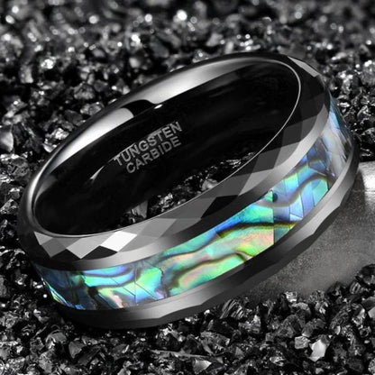 Black mens wedding band with faceted edges and vibrant abalone shell inlay.