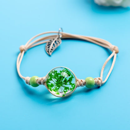 Adjustable botanical bracelet with a real preserved specimen displayed beneath a clear round centerpiece.