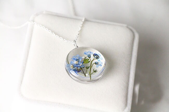 Delicate botanical pendant featuring real preserved blue flowers.