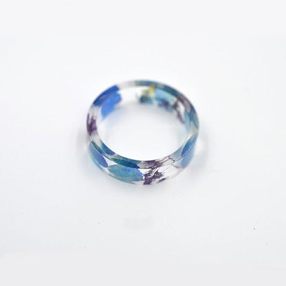 Delicate resin ring with preserved blue forget me nots and purple queen anne's lace.
