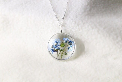 Floral pendant hanging from its adjustable silver chain.