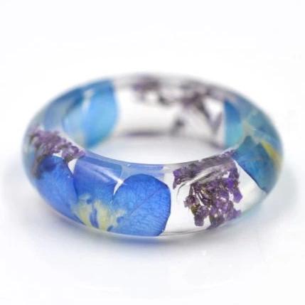 Forget me not ring with real blue flowers inside a clear resin band.