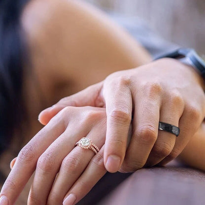 Hammered black tungsten ring shown on hand.