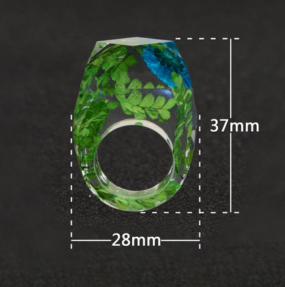 Ring mit echten blauen Blumen und Farnen