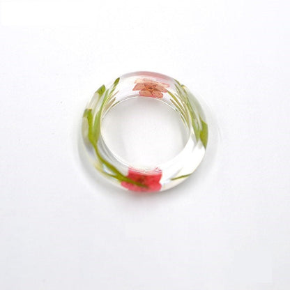 Ring aus rosa Blumen und grünem Moosharz