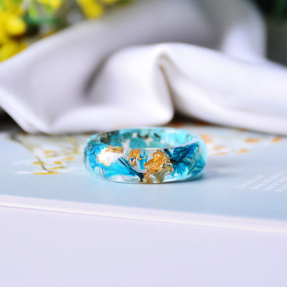 Botanischer Ring mit türkisen und blauen Blumen