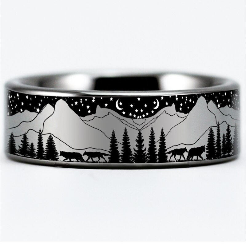 Mens wolf ring jewelry with a Tungsten band showing wolves, pine trees, and mountains.