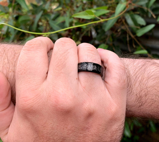 Meteorite ring mens with black Tungsten in outdoor setting.