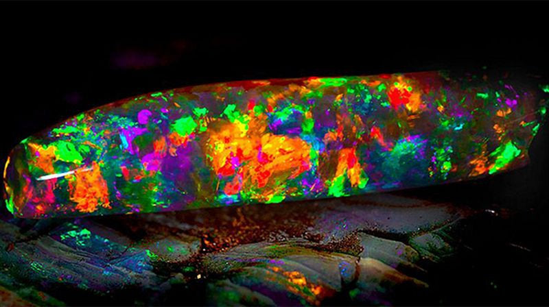 Natural opal stone displaying vibrant rainbow flashes of color.