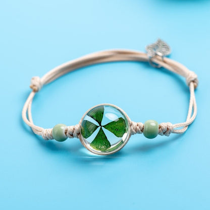 Nature-inspired bracelet featuring a preserved botanical centerpiece, beads and a small silver leaf charm.