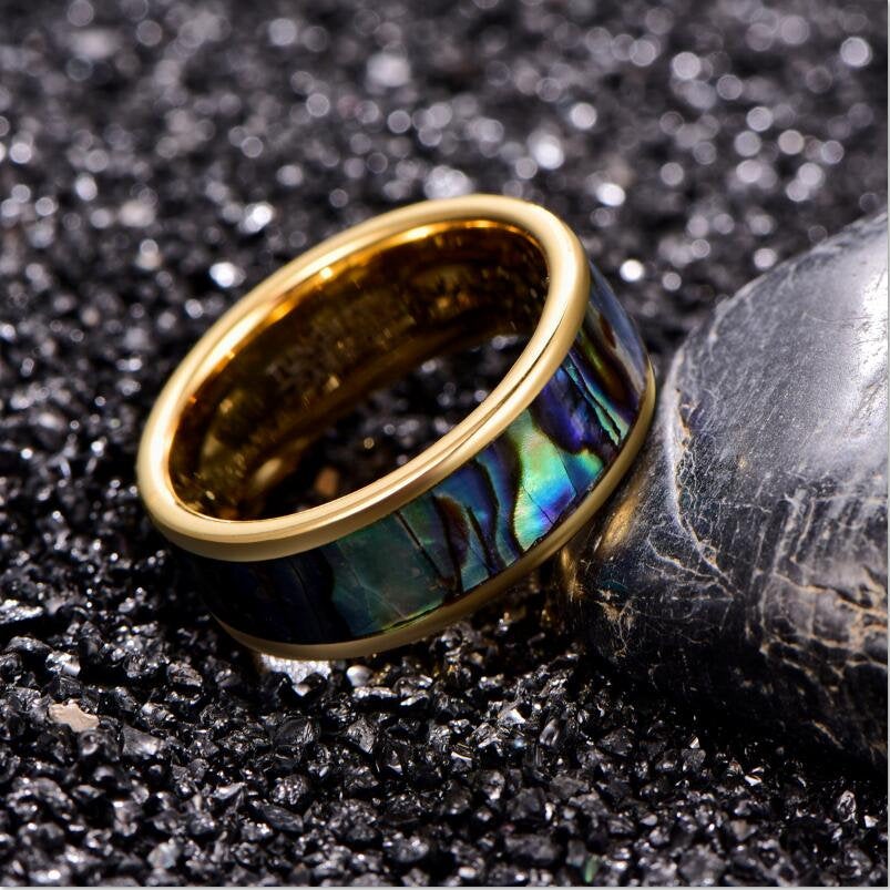 Ocean inspired wedding rings crafted from gold Tungsten with a colorful abalone inlay.