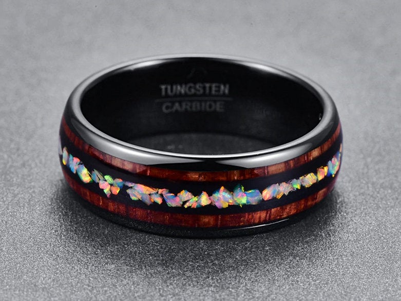 Opal mens wedding band crafted with polished black Tungsten, natural opal, and Koa wood inlays.