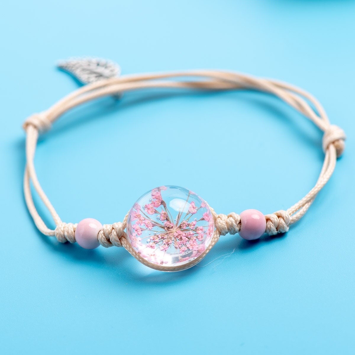 Pink flower bracelet with soft pink beads and an adjustable cord.