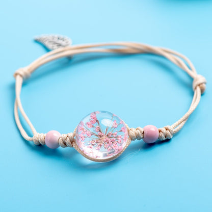 Pink flower bracelet with soft pink beads and an adjustable cord.