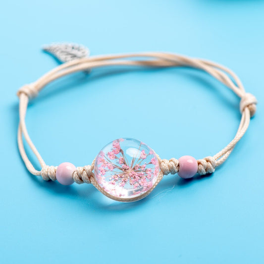 Pink flower bracelet with soft pink beads and an adjustable cord.