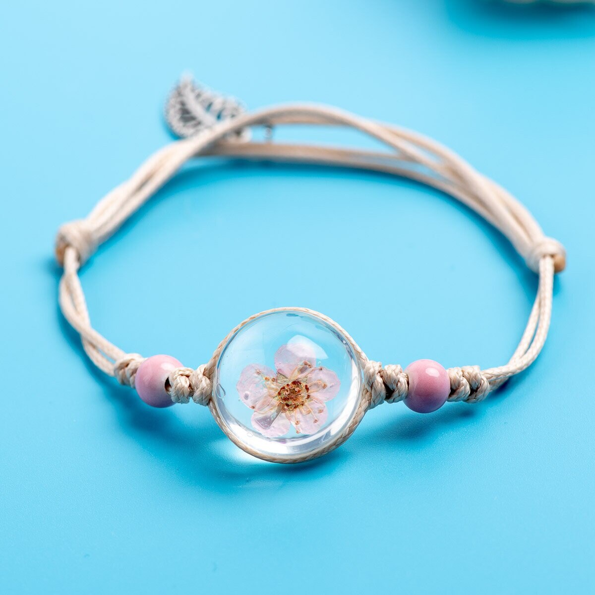 Preserved flower jewelry featuring a genuine forget-me-not blossom.